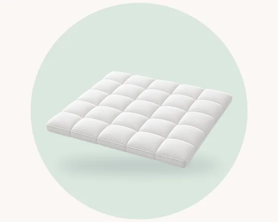 Product illustration: a thick white quilted mattress topper with square stitched panels, on a pale green pastel circle