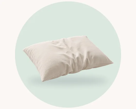 Product illustration: a relaxed linen pillowcase with a gently textured, slightly crumpled weave, on a pale pastel circle